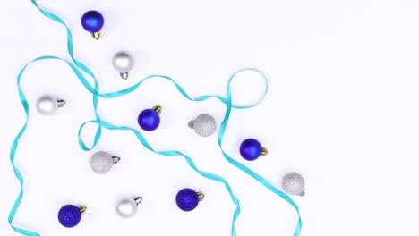 los adornos de navidad azules y la cinta aparecen en el tema blanco.