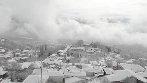 aerial footage over snowy mountain, traditional village in greece 7