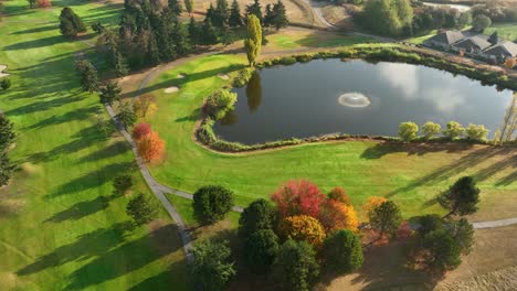 wide aerial view of a golf course water feature during an autumn sunrise