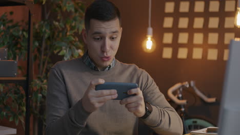 man playing mobile game in office