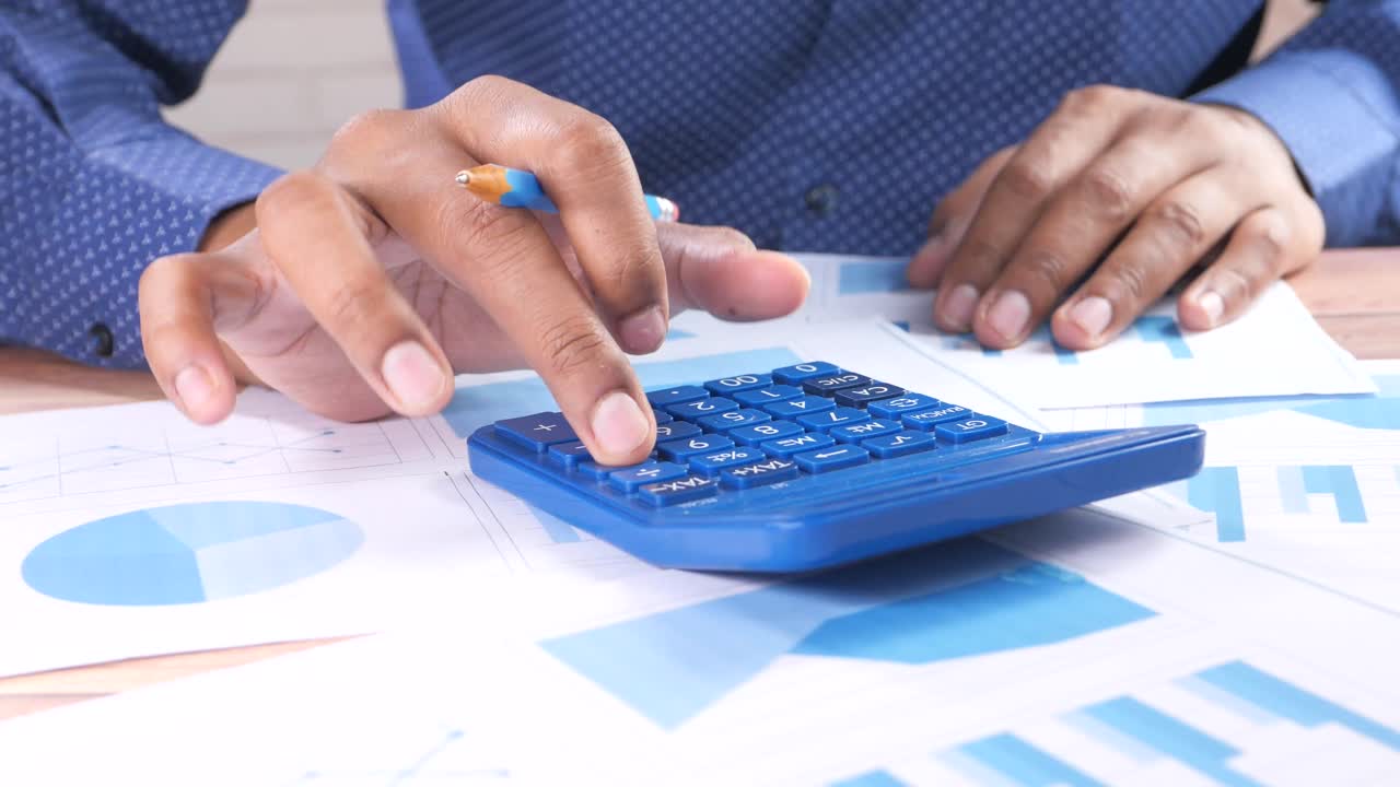 persona de negocios que utiliza calculadora y gráficos