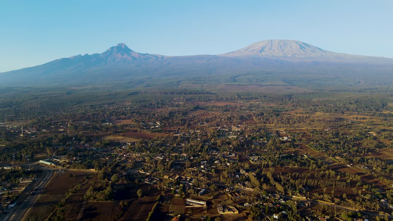 amanecer paisaje de kenya con una aldea, kilimanjaro y parque nacional de amboseli - seguimiento, vista aérea de avión no tripulado