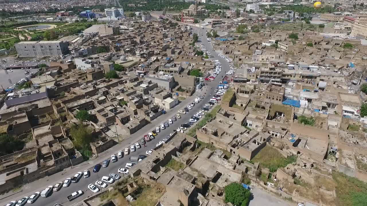 Una veduta aerea della città di Erbil che mostra l'antica Cittadella di Erbil e il giardino di fronte al castello con fontane d'acqua e il popolare mercato