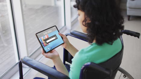 Biracial-woman-sitting-in-wheelchair-using-tablet-for-online-shopping,-slow-motion