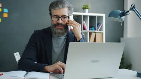 businessman working on laptop and talking on the phone
