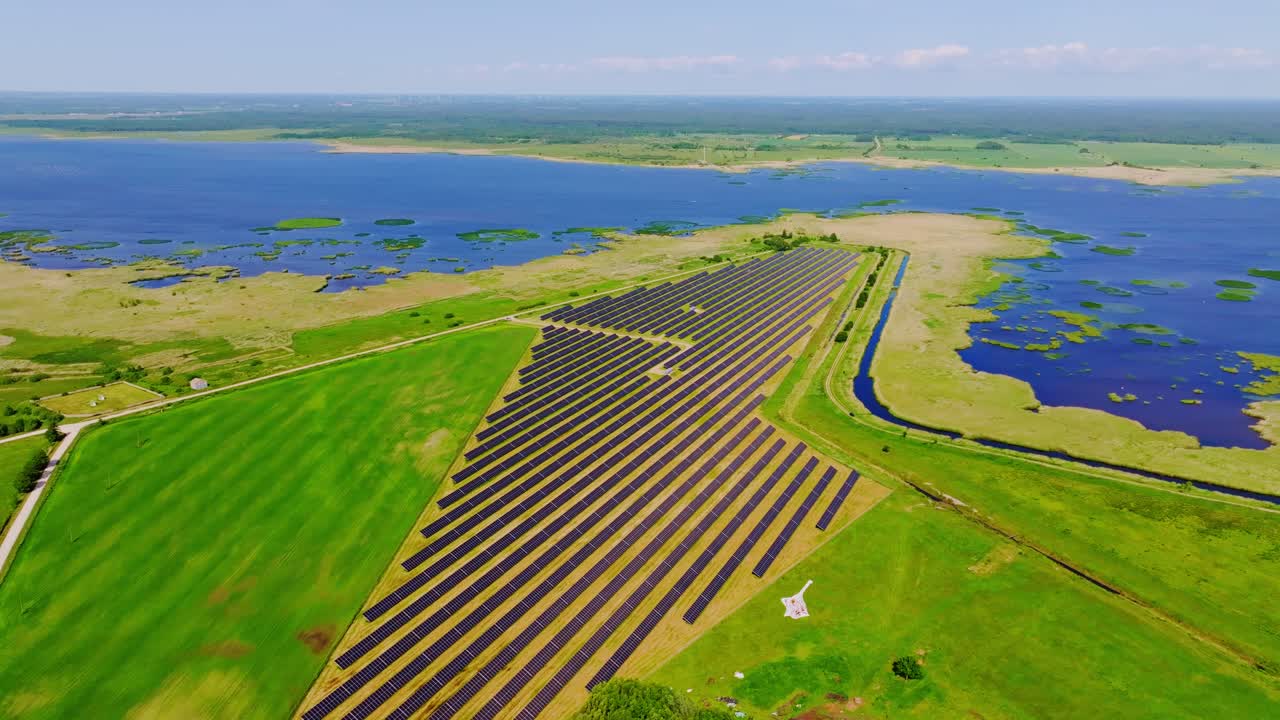 Cinematic Drone View Shows Solar Park Near Liepāja Lake Amid Wetland Ecosystem