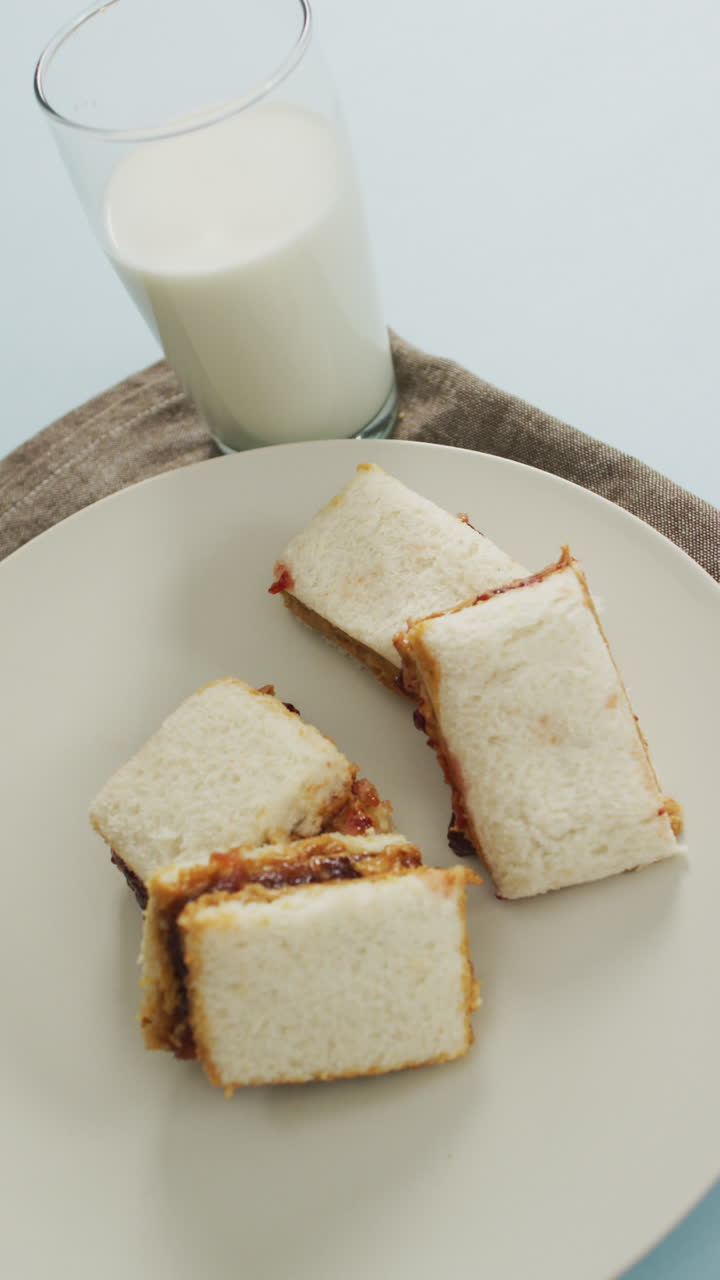 video vertical de sándwiches en un plato y un vaso de leche