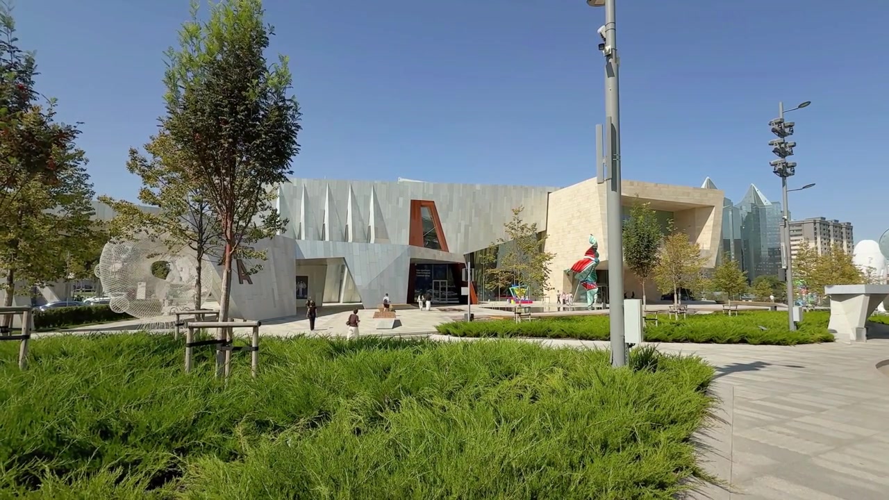 Fachada moderna do edifício do Museu de Artes de Almaty e praça ensolarada em Almaty, Cazaquistão