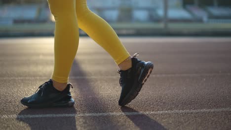 woman running on outdoor track in yellow sportswear