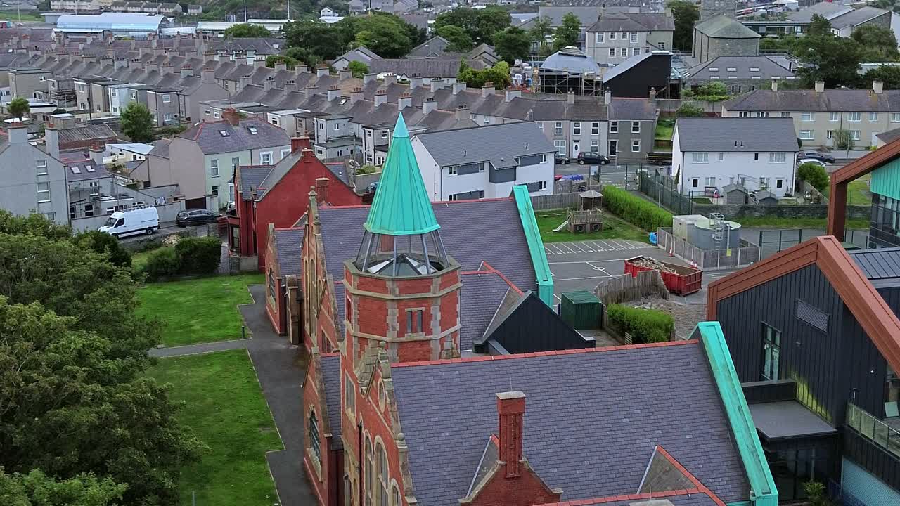 Ysgol Cybi welsh primary school aerial view circling across green copper spire and Holyhead suburb