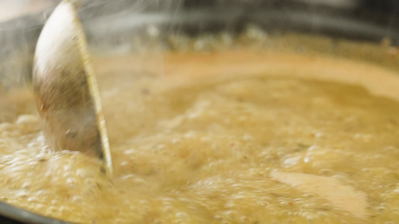Cooking traditional Indian meal Palak Panir with spinach and cheese close up. Palak paneer is an Indian dish, consisting of paneer in a thick paste made from pureed spinach, Palak paneer is prepared by first boiling and pureeing spinach.