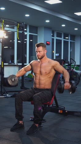 man doing dumbbell shoulder exercises in a gym.