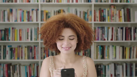 retrato de una mujer afroamericana estudiante sonriente estantería biblioteca universidad