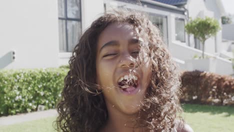 Retrato-De-Una-Feliz-Niña-Afroamericana-Saltando-Y-Sonriendo-En-El-Jardín,-Cámara-Lenta