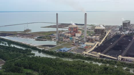 toma aérea de la cuenca carbonífera costera, planta de energía industrial ultrasupercrítica alimentada con carbón con humo saliendo de la chimenea ubicada en la terminal a granel de lekir jalan, teluk rubiah, manjung, perak, malasia