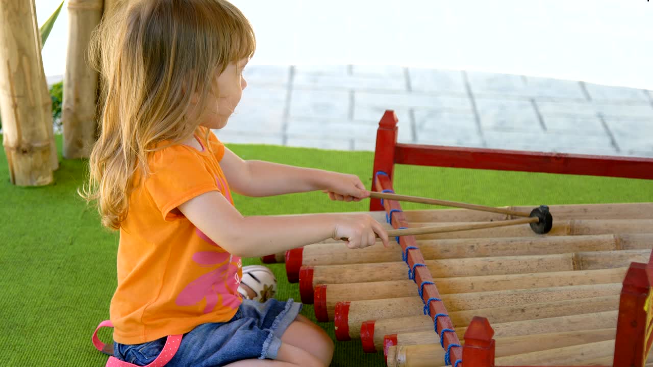 una niña tocando instrumentos tradicionales indonesios