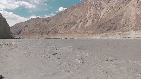 the-mind-calming-video-of-flow-of-shyok-river-in-between-two-mountains-and-beautiful-blue-sky-in-the-ladakh-region