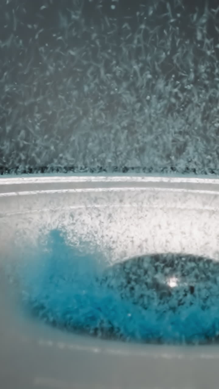 Bright blue powder flies up near dust cap. Movement of modern dynamic speaker diaphragm. Acoustic experiment on study of sound waves against black wall macro