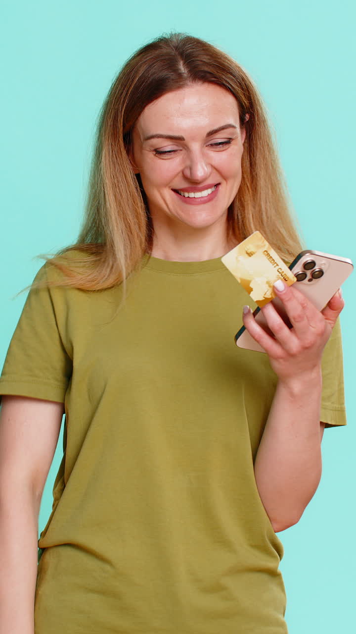 Woman holding smartphone credit card making online purchase clicking order with focused expression