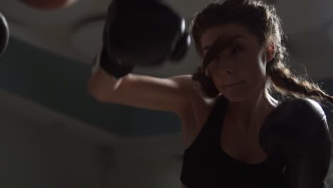 young attractive woman in boxing gloves training with her couch in a boxing club. slow motion shot