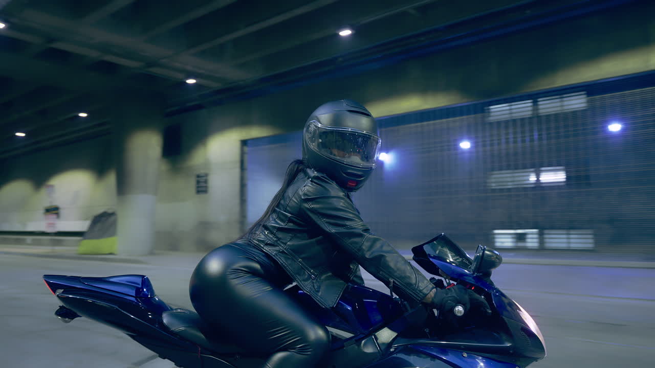 la cámara gira alrededor de una mujer sentada en una motocicleta en la calle en el centro de los angeles, ca