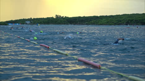 Weitwinkelaufnahme-Von-Schwimmern-In-Zeitlupe,-Die-Frühmorgens-An-Einem-Triathlon-Im-Meer-Teilnehmen