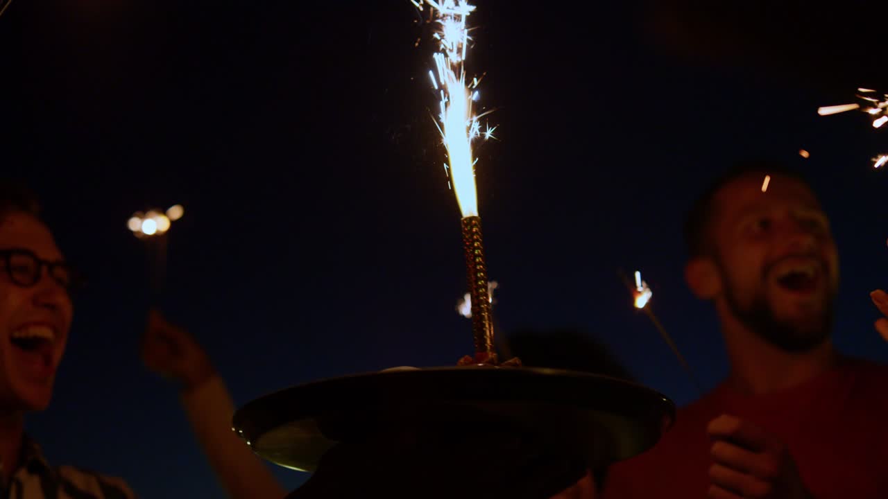 gente disfrutando de luces de bengala fiesta de cumpleaños. amigos divirtiéndose con fuegos artificiales