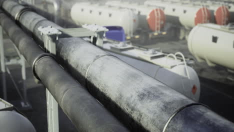 industrial pipes and tanks at a processing facility under cloudy sky