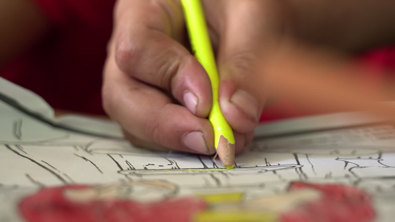 las manos de los niños escribiendo la tarea con un lápiz de colores
