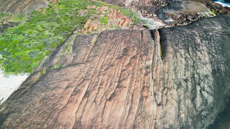 Tilt-View-of-Cape-Leeuwin-Lighthouse-Landmark-with-Parallel-Fissured-Rocks,-Australia