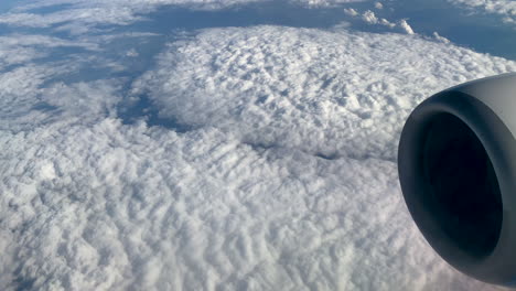 thick carpet of fluffy stratus clouds seen from window airplane on flight