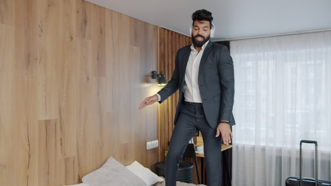 Uomo d'affari che balla sul letto d'albergo