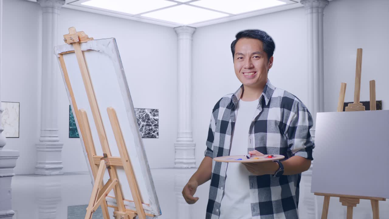 ギャラリーで笑顔のアーティストが親指を上げている