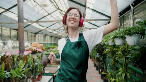 nature's dance: a joyful journey through a flower shop. a girl in a green apron is a happy employee of flower shops dancing in