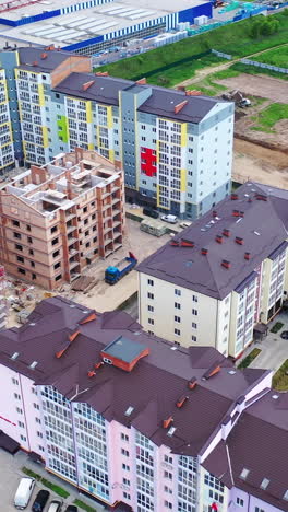 construction of a new residential complex. modern multi-storey buildings build in the city. construction site with high cranes. aerial view. vertical video