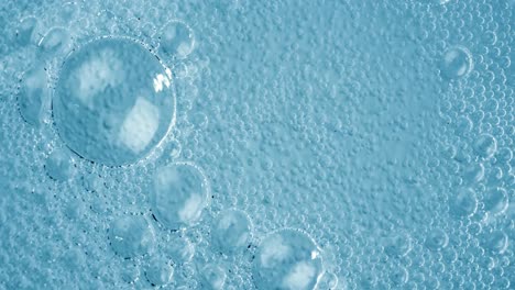 oxygen bubbles in water on a blue abstract background on super slow motion.