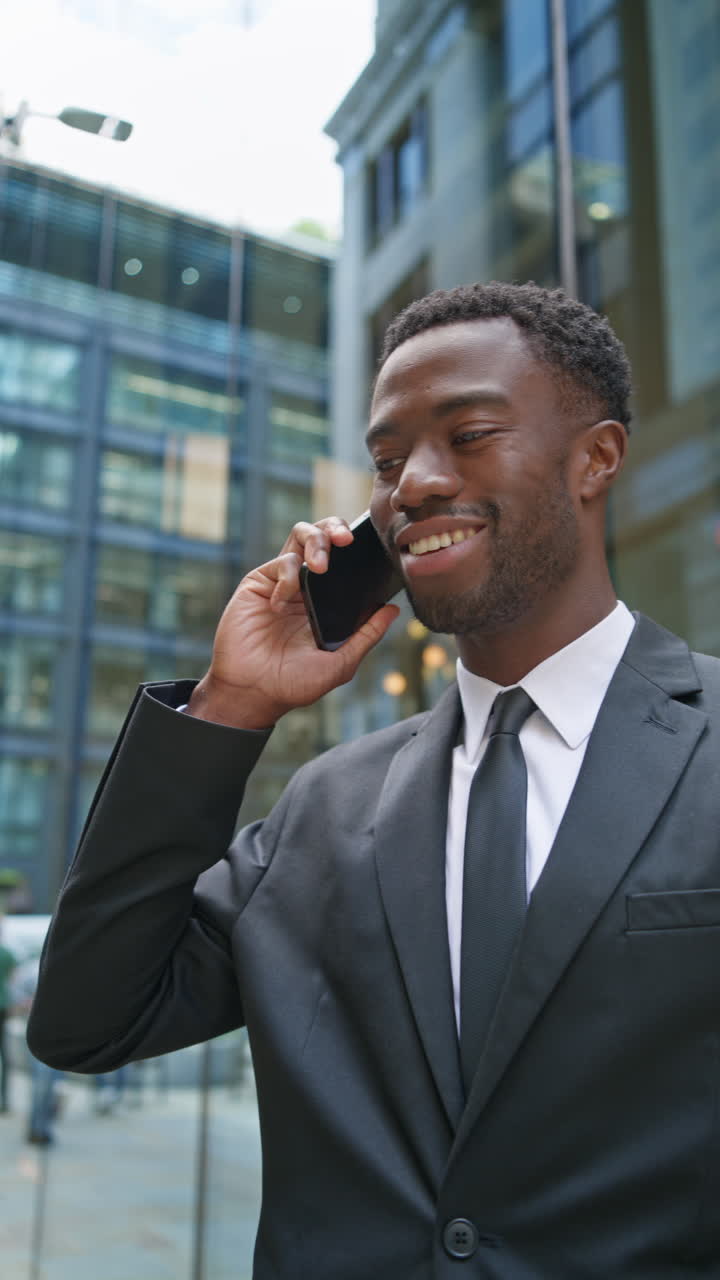 Vertical Video Of Young Businessman Wearing Suit Making Call On Mobile Phone Standing Outside Offices In The Financial District Of The City Of London UK Shot In Real Time