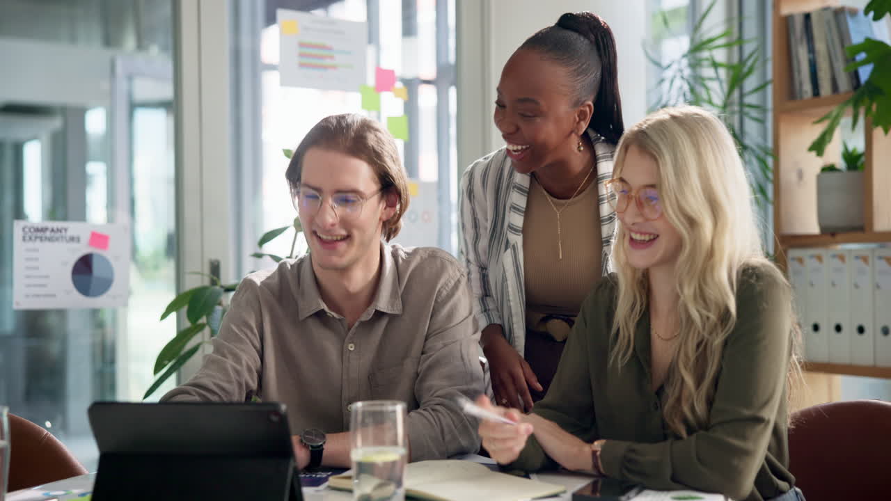 Three business people in a meeting collaborating on a tablet