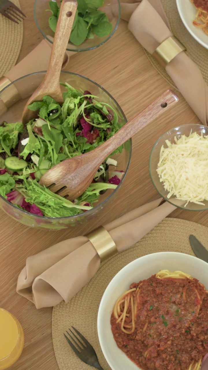 Bambino che si china verso gli spaghetti, ritraendosi e causando uno spostamento della telecamera, centrando l'insalata per la cena