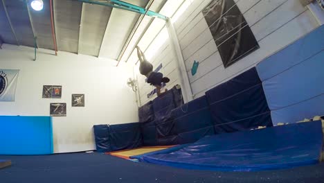 a slow motion still shot of a guy doing flips from the trampoline landing and winning having fun and working out in 60fps