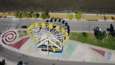 top-down view of ferris wheel slowly revealing the bay of seixal - aerial shot