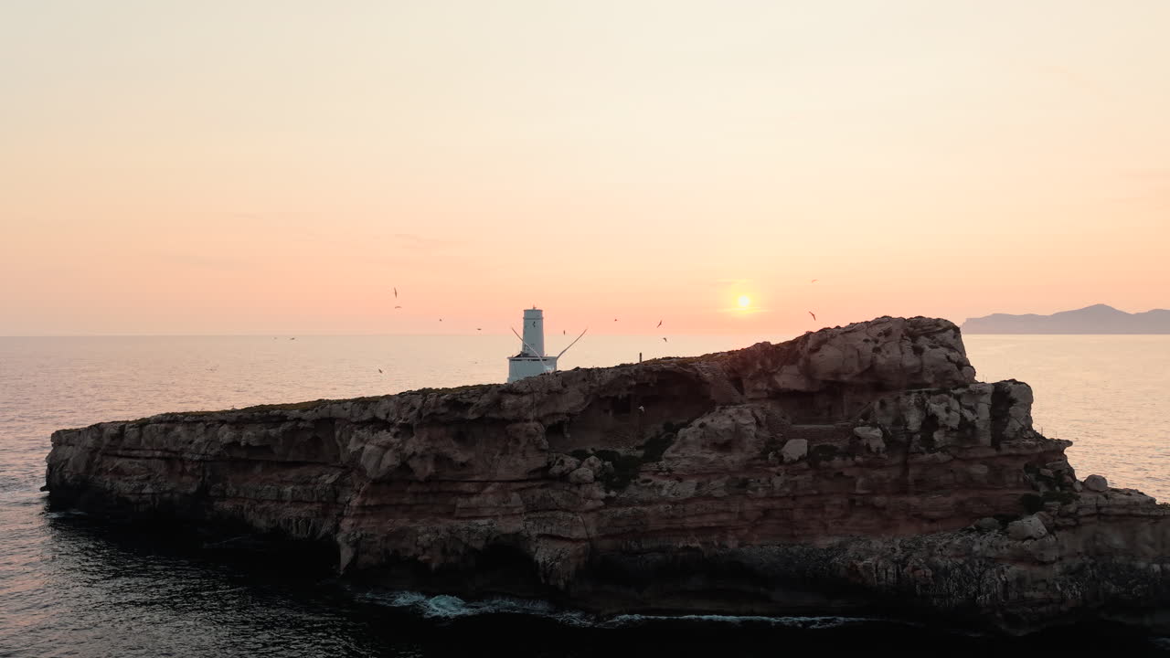 Fyr på en klippeø ved solnedgang