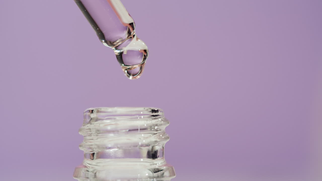 Dropper dispensing liquid into a bottle
