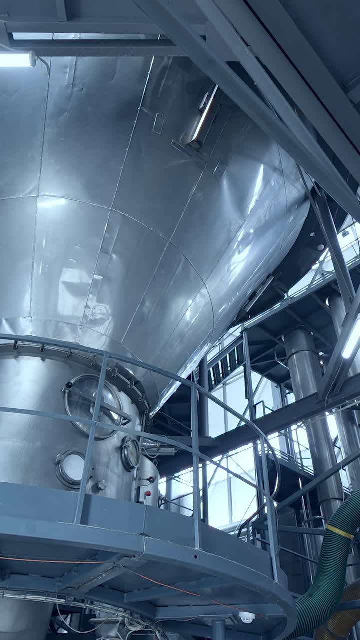 Big steel construction of milk factory. Modern food pipelines technology. Vertical video