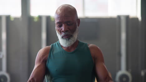 muscular senior man working out at the gym