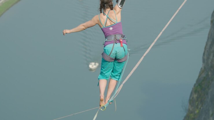 Nehir üzerinde yüksekte duran bir kadının muhteşem sinematik yüksek ip slackline'ı.
