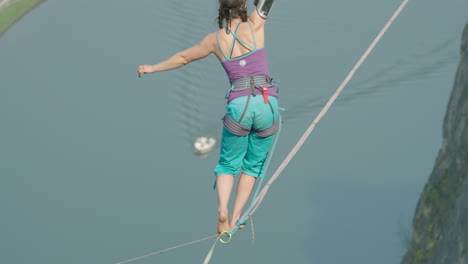 amazing cinematic high line slack line of woman high above river