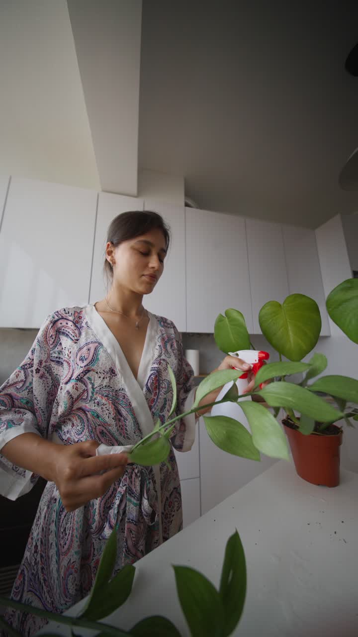 Woman Caring for Houseplants in a Kitchen