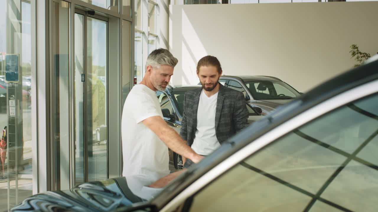 Two Men Discussing Cars in a Showroom