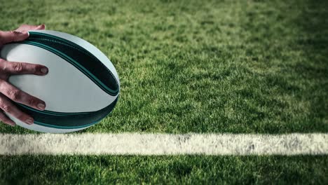 animation of hands of caucasian male rugby player holding ball over stadium